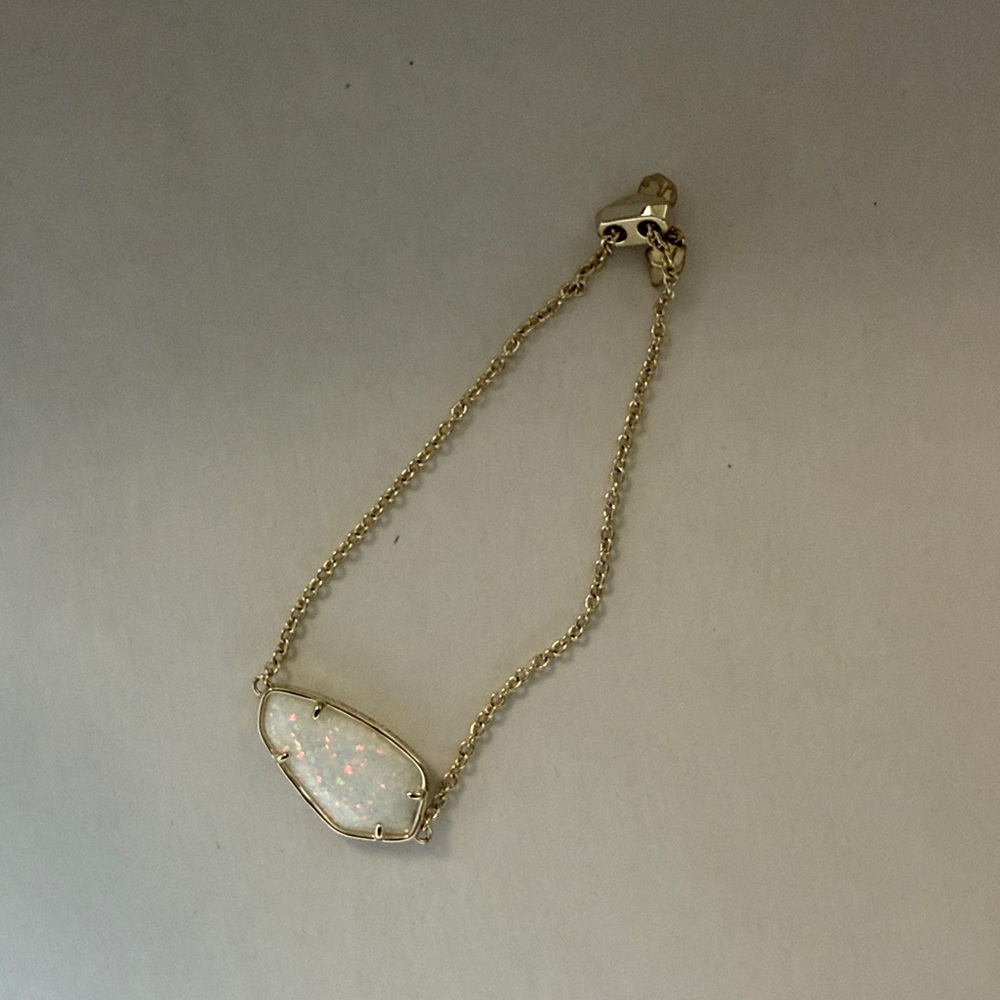 Kendra Scott gold bracelet with opal/white stone